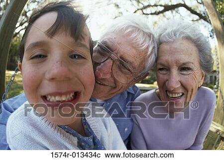 Stock Image - Portrait of a granddaughter smiling with her grandparents. Fotosearch