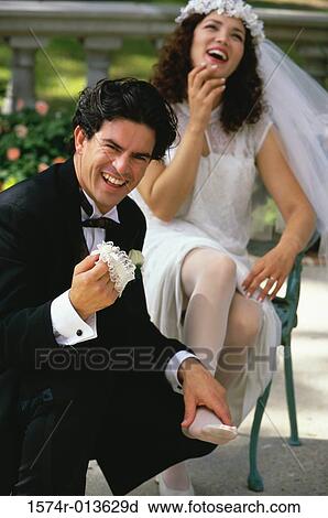 Portrait of a groom holding the feet of his bride and laughing View Large Photo Image Stock Image - Portrait of a groom holding the feet of his bride and laughing. Fotosearch