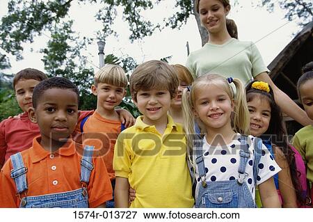 Portrait of a group of students smiling with their teacher standing behind them View Large Photo Image Stock Photo - Portrait of a group of students smiling with their teacher standing behind them. Fotosearch