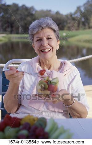Portrait of a mature woman eating fruit salad View Large Photo Image Stock Image - Portrait of a mature woman eating fruit salad. Fotosearch