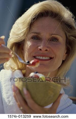 Stock Photo - Portrait of a mature woman holding a bowl of fruit salad. Fotosearch