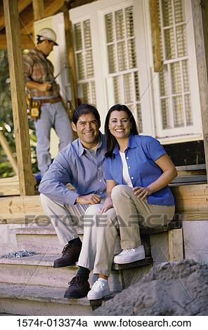 Portrait of a mid adult couple sitting on steps in front of their new house View Large Photo Image Stock Image - Portrait of a mid adult couple sitting on steps in front of their new house. Fotosearch