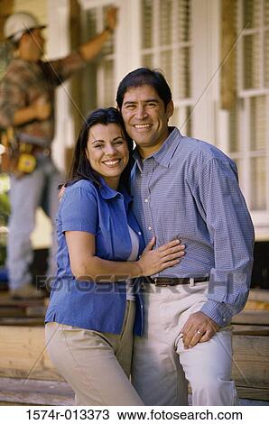 Portrait of a mid adult couple smiling in front of their new house View Large Photo Image Stock Image - Portrait of a mid adult couple smiling in front of their new house. Fotosearch