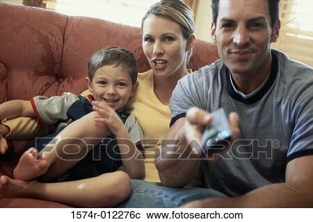 Portrait of a mid adult couple watching television with their son View Large Photo Image Stock Image - Portrait of a mid adult couple watching television with their son. Fotosearch