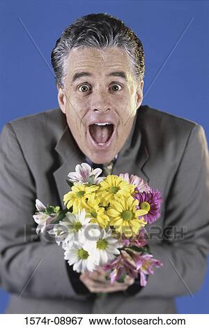 Stock Photo - Portrait of a mid adult man holding a bouquet of flowers. Fotosearch