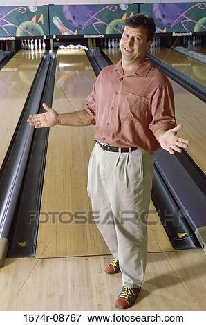 Stock Photo - Portrait of a mid adult man in a bowling alley. Fotosearch