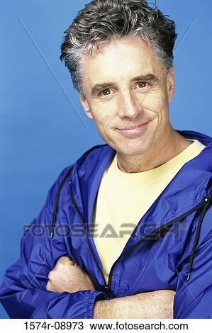 Portrait of a mid adult man standing with his arms folded smiling View Large Photo Image Stock Image - Portrait of a mid adult man standing with his arms folded smiling. Fotosearch