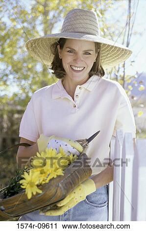 Portrait of a mid adult woman holding a basket of daisies View Large Photo Image Stock Image - Portrait of a mid adult woman holding a basket of daisies. Fotosearch