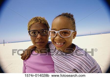 Stock Image - Portrait of a mother and daughter wearing sunglasses. Fotosearch