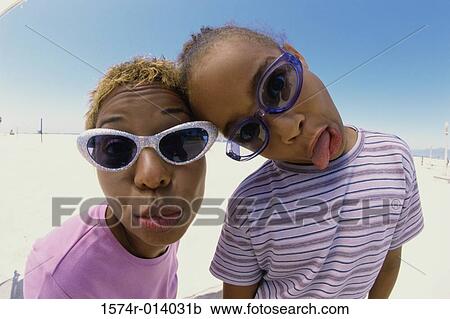 Stock Image - Portrait of a mother and her daughter puckering their lips. Fotosearch