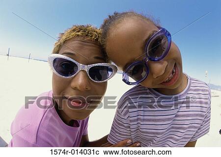 Stock Image - Portrait of a mother and her daughter puckering their lips. Fotosearch