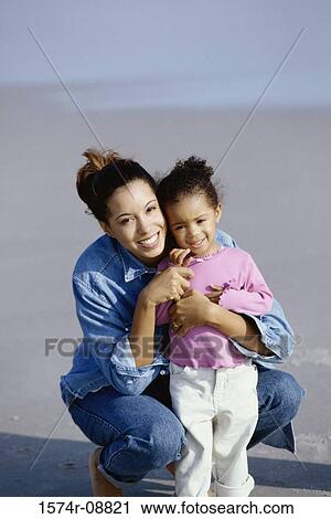 Portrait of a mother and her daughter playing together on the beach View Large Photo Image Stock Image - Portrait of a mother and her daughter playing together on the beach. Fotosearch
