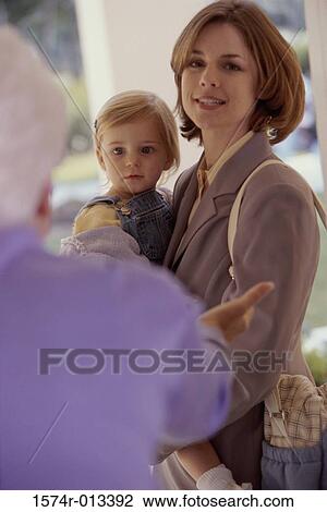 Stock Image - Portrait of a mother carrying her daughter. Fotosearch
