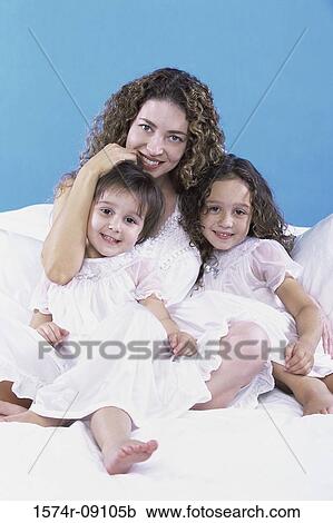 Stock Image - Portrait of a mother holding her two daughters. Fotosearch