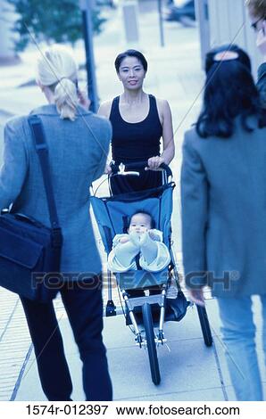 Stock Photo - Portrait of a mother pushing her son in a baby stroller. Fotosearch
