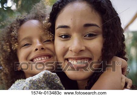 Stock Image - Portrait of a mother smiling with her daughter. Fotosearch
