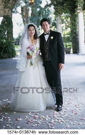 Portrait of a newlywed couple standing together View Large Photo Image Stock Image - Portrait of a newlywed couple standing together. Fotosearch