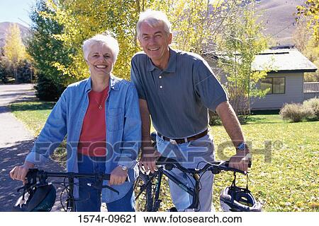 Portrait of a senior couple holding bicycles View Large Photo Image Stock Image - Portrait of a senior couple holding bicycles. Fotosearch