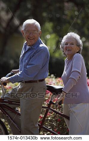 Portrait of a senior couple on a tandem bicycle View Large Photo Image Stock Image - Portrait of a senior couple on a tandem bicycle. Fotosearch