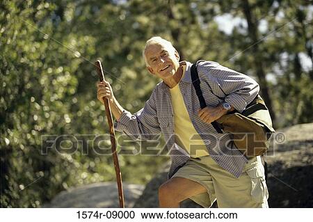 Portrait of a senior man holding a hiking pole View Large Photo Image Stock Image - Portrait of a senior man holding a hiking pole. Fotosearch