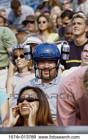 Portrait of a spectator wearing a football helmet View Large Photo Image Stock Photo - Portrait of a spectator wearing a football helmet. Fotosearch