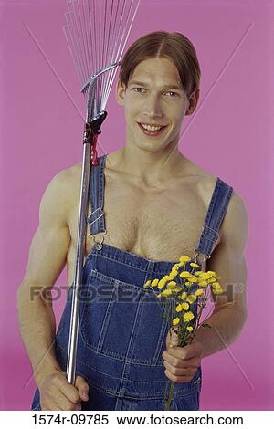 Portrait of a teenage boy holding a rake and flowers View Large Photo Image Stock Photography - Portrait of a teenage boy holding a rake and flowers. Fotosearch