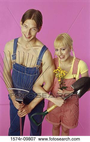 Portrait of a teenage couple holding a rake and a shovel View Large Photo Image Stock Photo - Portrait of a teenage couple holding a rake and a shovel. Fotosearch