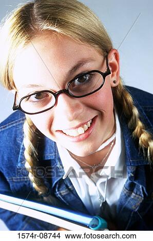 Portrait of a teenage girl holding a book smiling View Large Photo Image Picture - Portrait of a teenage girl holding a book smiling. Fotosearch