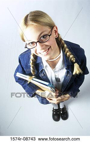 Portrait of a teenage girl holding books View Large Photo Image Stock Image - Portrait of a teenage girl holding books. Fotosearch