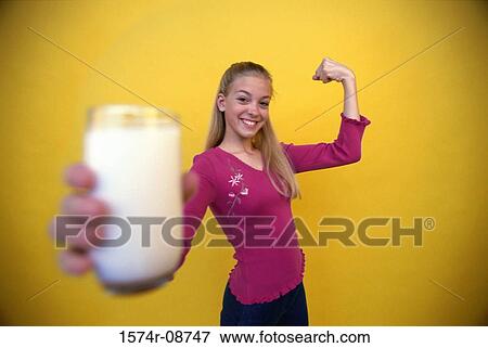 Stock Photo - Portrait of a teenage girl holding out a glass of milk. Fotosearch