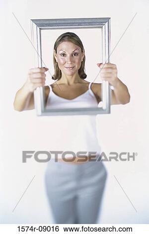 Portrait of a woman holding a picture frame View Large Photo Image Stock Photograph - Portrait of a woman holding a picture frame. Fotosearch