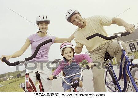 Portrait of a young couple cycling with their daughter View Large Photo Image Stock Image - Portrait of a young couple cycling with their daughter. Fotosearch