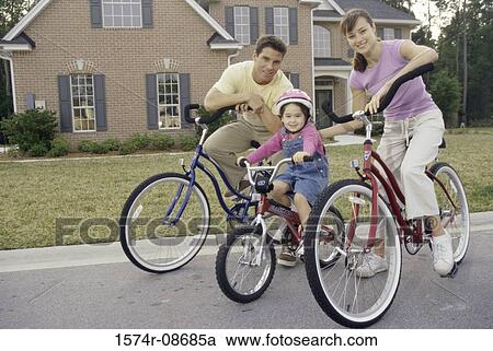 Portrait of a young couple cycling with their daughter View Large Photo Image Stock Image - Portrait of a young couple cycling with their daughter. Fotosearch