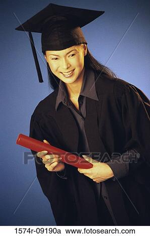 Stock Image - Portrait of a young female graduate holding a diploma. Fotosearch
