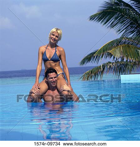 Picture - Portrait of a young man carrying a young woman on his shoulders. Fotosearch