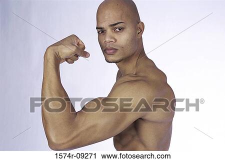 Portrait of a young man flexing his biceps View Large Photo Image Stock Image - Portrait of a young man flexing his biceps. Fotosearch