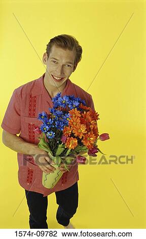 Portrait of a young man holding a bouquet of flowers View Large Photo Image Stock Image - Portrait of a young man holding a bouquet of flowers. Fotosearch