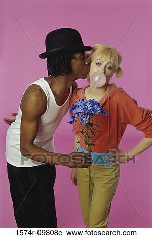 Stock Image - Portrait of a young man kissing a young woman. Fotosearch