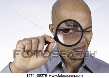 Portrait of a young man looking through a magnifying glass View Large Photo Image Stock Photograph - Portrait of a young man looking through a magnifying glass. Fotosearch