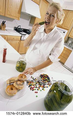 Portrait of a young pregnant woman eating pickles View Large Photo Image Stock Image - Portrait of a young pregnant woman eating pickles. Fotosearch