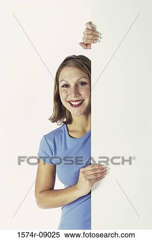 Portrait of a young woman behind a wall View Large Photo Image Stock Photography - Portrait of a young woman behind a wall. Fotosearch