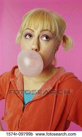 Stock Image - Portrait of a young woman blowing bubble gum. Fotosearch
