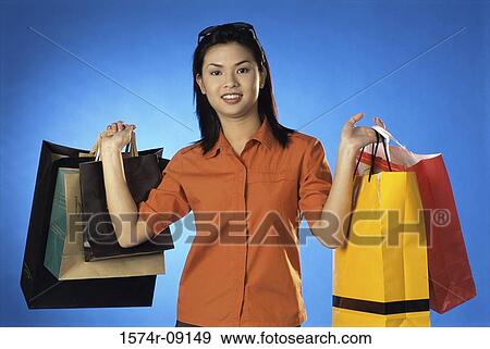 Portrait of a young woman carrying shopping bags View Large Photo Image Stock Photo - Portrait of a young woman carrying shopping bags. Fotosearch