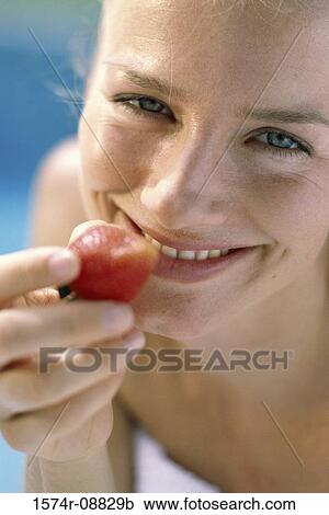 Portrait of a young woman eating a strawberry View Large Photo Image Stock Image - Portrait of a young woman eating a strawberry. Fotosearch