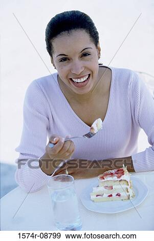 Portrait of a young woman eating a slice of cake View Large Photo Image Stock Photo - Portrait of a young woman eating a slice of cake. Fotosearch