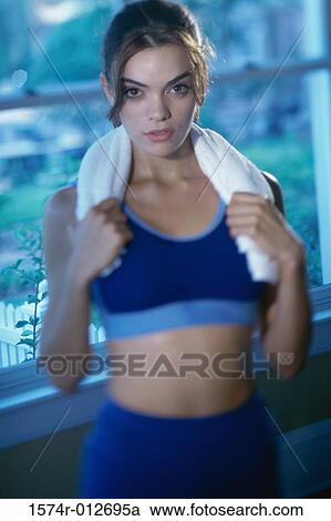 Stock Image - Portrait of a young woman holding a towel around her neck. Fotosearch