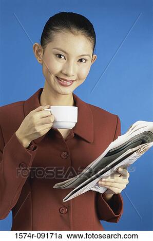 Stock Image - Portrait of a young woman holding a teacup. Fotosearch