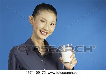 Portrait of a young woman holding a glass of milk View Large Photo Image Stock Image - Portrait of a young woman holding a glass of milk. Fotosearch