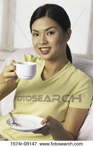 Portrait of a young woman holding a teacup View Large Photo Image Stock Photo - Portrait of a young woman holding a teacup. Fotosearch