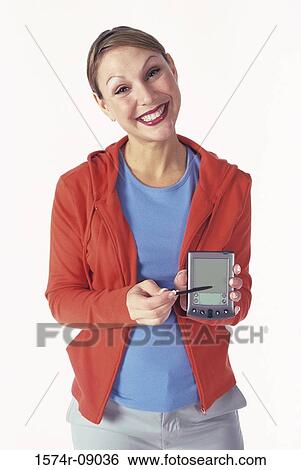 Portrait of a young woman holding a hand held device View Large Photo Image Stock Photograph - Portrait of a young woman holding a hand held device. Fotosearch